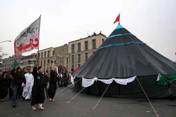 دسته ای عزادار حول خیمه به چرخش در می آیند و ذکر مصیبت امام شهید را به زبان جاری می کنند 